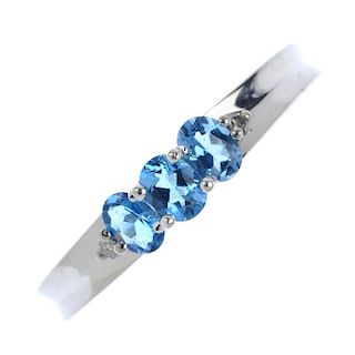 A platinum topaz and diamond dress ring. The oval-shape blue topaz line, with single-cut diamond acc