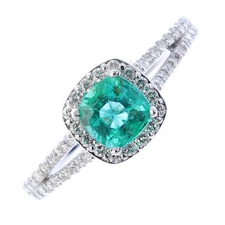* An emerald and diamond cluster ring. The cushion-shape emerald, within a brilliant-cut diamond bor