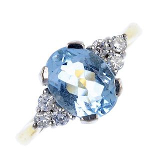 An 18ct gold aquamarine and diamond dress ring. The oval-shape aquamarine, to the brilliant-cut diam
