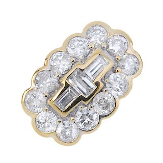 An 18ct gold diamond cluster ring. The baguette-cut diamond three-stone line, within a brilliant-cut