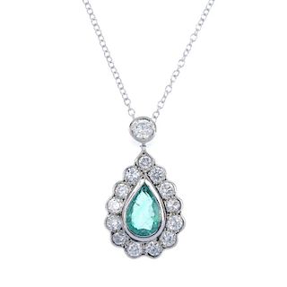 An emerald and diamond cluster pendant. The pear-shape emerald, within a brilliant-cut diamond scall