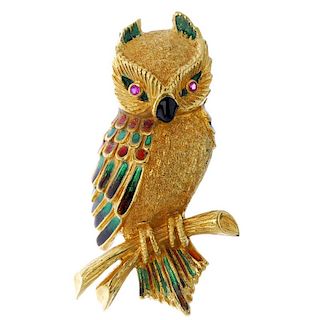 An enamel and gem-set owl brooch. Designed as an owl perching atop a branch, with vari-shade enamel