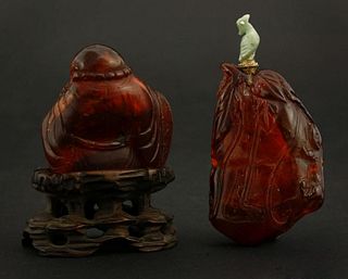 An amber Budai 18th/19th century seated holding a fly
