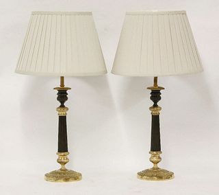 A pair of Regency bronze and parcel gilt candlesticks,