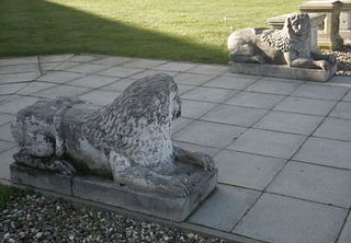 A pair of Venetian-style composition recumbent stone
