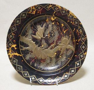 A faux tortoiseshell dish decorated in gilt with cranes within a geometric border, 26cm diameter <br