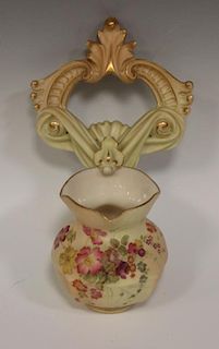 A Royal Worcester blush ivory wall pocket, floral painted, tied ribbon motif above, green mark and 3