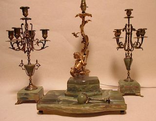 An onyx inkwell and pair of matched candelabra together with a modern lamp with putti at base and a