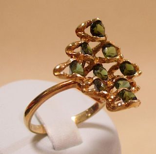 An 18ct gold dress ring set with nine green stones <br> <br>