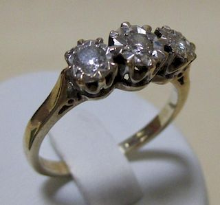 A 9ct three stone illusion set diamond ring, a 9ct emerald and diamond ring, a 9ct three stone perid