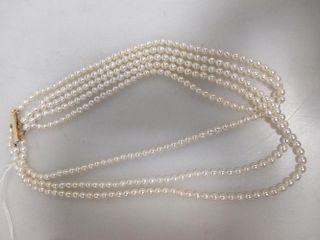 A three strand necklace of 4mm pearls on gold clasp stamped '14k', length 36cm <br> <br>