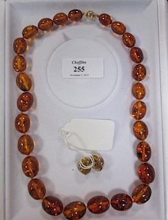 A Cellini amber bead necklace with 18ct gold ball clasp (46g), and a matching round cabochone earing