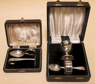 A cased silver silver spoon and pusher, cased silver egg cup, spoon and napkin ring together with a