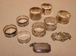 Eight silver napkin rings and two wine labels <br> <br>