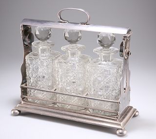 A LATE VICTORIAN SILVER-PLATED THREE-BOTTLE TANTALUS, with bun feet, the cu