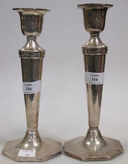 A pair of silver table candlesticks by Walker & Hall, Sheffield 1924, raised on octagonal feet <br>