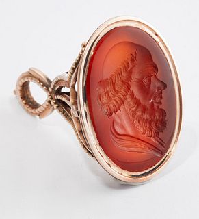 A CARNELIAN INTAGLIO FOB SEAL, the oval carnelian carved depicting the prof