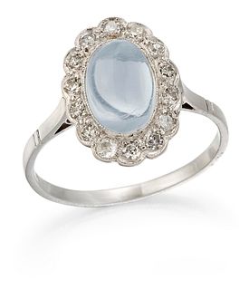 A MOONSTONE AND DIAMOND CLUSTER RING, an oval cabochon moonstone within a m