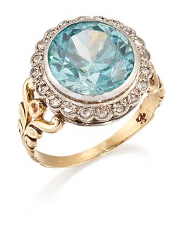 A BLUE ZIRCON AND DIAMOND CLUSTER RING, a round-cut blue zircon within a bo