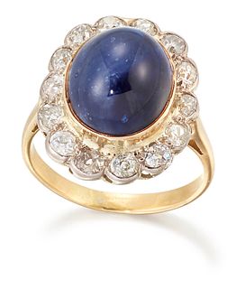 A SAPPHIRE AND DIAMOND CLUSTER RING, an oval-cabochon sapphire in a bezel s