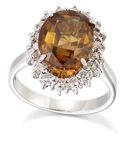 AN 18 CARAT WHITE GOLD ZIRCON AND DIAMOND CLUSTER RING, an oval-cut brown-g