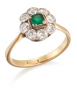 AN EMERALD AND DIAMOND CLUSTER RING, a square octagonal-cut emerald within 