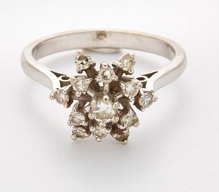 A DIAMOND CLUSTER RING, a hexagonal cluster of round-cut diamonds in extend