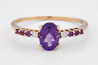 A 9 CARAT GOLD AMETHYST AND DIAMOND RING, an oval-cut amethyst spaced by ro