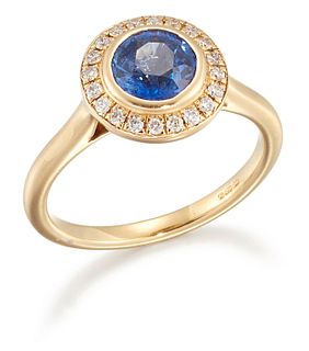 AN 18 CARAT GOLD SAPPHIRE AND DIAMOND CLUSTER RING, a round-cut sapphire wi