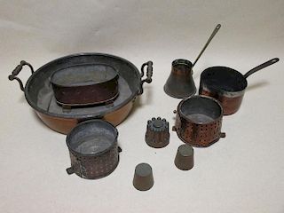 A collection of copper kitchen wares including a two handled pan, miniature jelly mould and other co