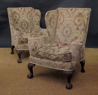 A pair of 20th century wing back armchairs upholstered in a pink cut velvet, on carved ball and claw