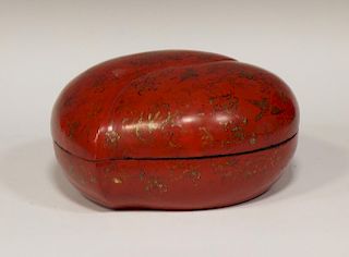 A Chinese red lacquered peach shaped box and cover, gilt with flowers and a black lacquered round bo
