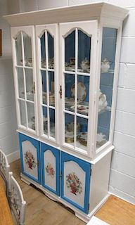 A painted bookcase, the white and blue painted glazed upper section with glass shelves, with white a
