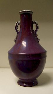 A purple flambe vase, the bracket handled neck flaring to a moulded band to the top of the hemispher