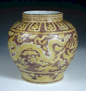 A Ming style jar, the body incised with white maned yellow dragons chasing flaming pearls against a