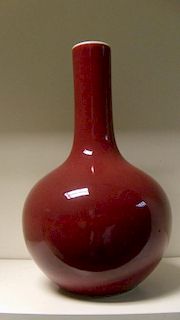 A sang du boeuf bottle vase, the white of the interior showing on the exterior rim above the red bod