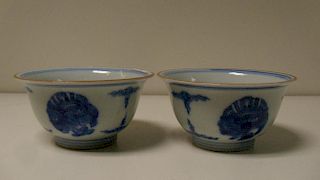 A pair of blue and white bowls, the exteriors painted with shishi roundels alternating with clouds,