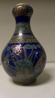 A blue ground famille rose onion topped bottle vase painted with mandarin ducks amongst lotus betwee