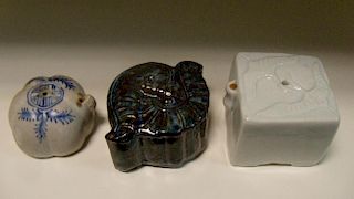 Three 19th century Korean water droppers, the square top of the white glazed example moulded with tw