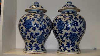 A pair of late 19th/early 20th century blue and white jars and covers, the baluster shapes painted w