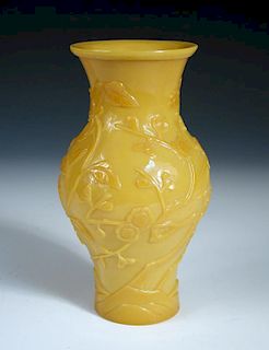 A late 19th century yellow glass vase, the exterior of the baluster shape carved in relief with cher