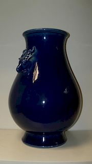 A 20th century blue glazed vase, the shoulders of the ovoid shape flaring up to the rims and applied