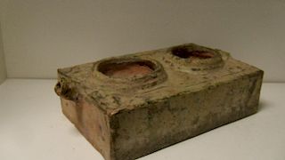 A Han green glazed red pottery model stove, the rectangular top recessed with two fire bowls, a spou