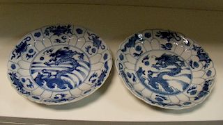 A pair of blue and white plates, period of Kangxi, the central carps and dragons rising from waves a