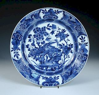 A blue and white dish, period of Kangxi, centrally painted with birds about a rock amongst peonies a