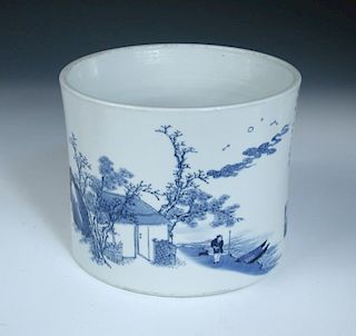 A 20th century blue and white brush pot painted with a man coming ashore to his pavilion, his moored