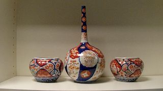 A late 19th/early 20th century Imari bottle vase and a pair of jars, the roundels on the spherical b