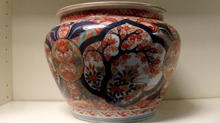 An early 20th century Imari planter, the exterior painted with four blue framed garden reserves link