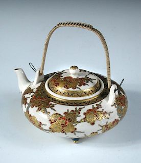 A late 19th/early 20th century Satsuma tea pot and cover, the squat globular body painted with red a