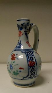 A late 17th/early 18th entury Kakiemon ewer, the ovoid body painted with three panels of flowers wit